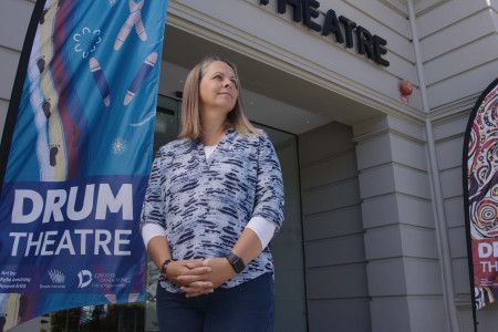 a person standing out front of Drum theatre